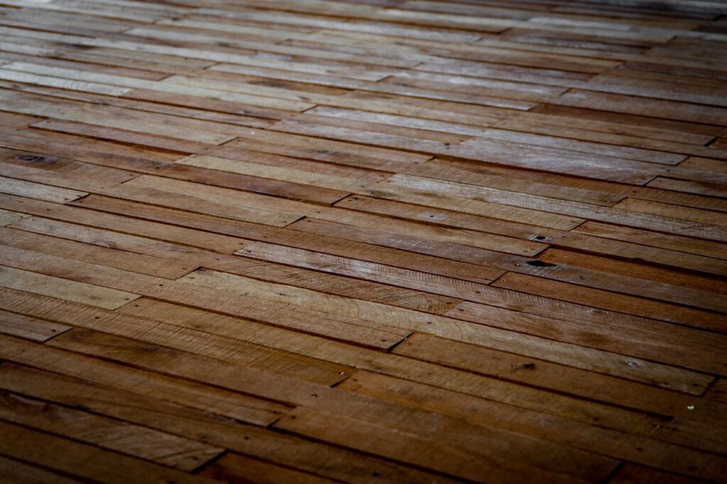 Detailed view of rustic wooden floor with staggered planks showcasing natural texture.